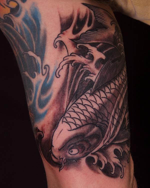 Black and grey koi fish bicep tattoo