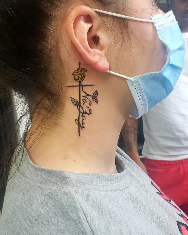 Rose and cross with name ear tattoo